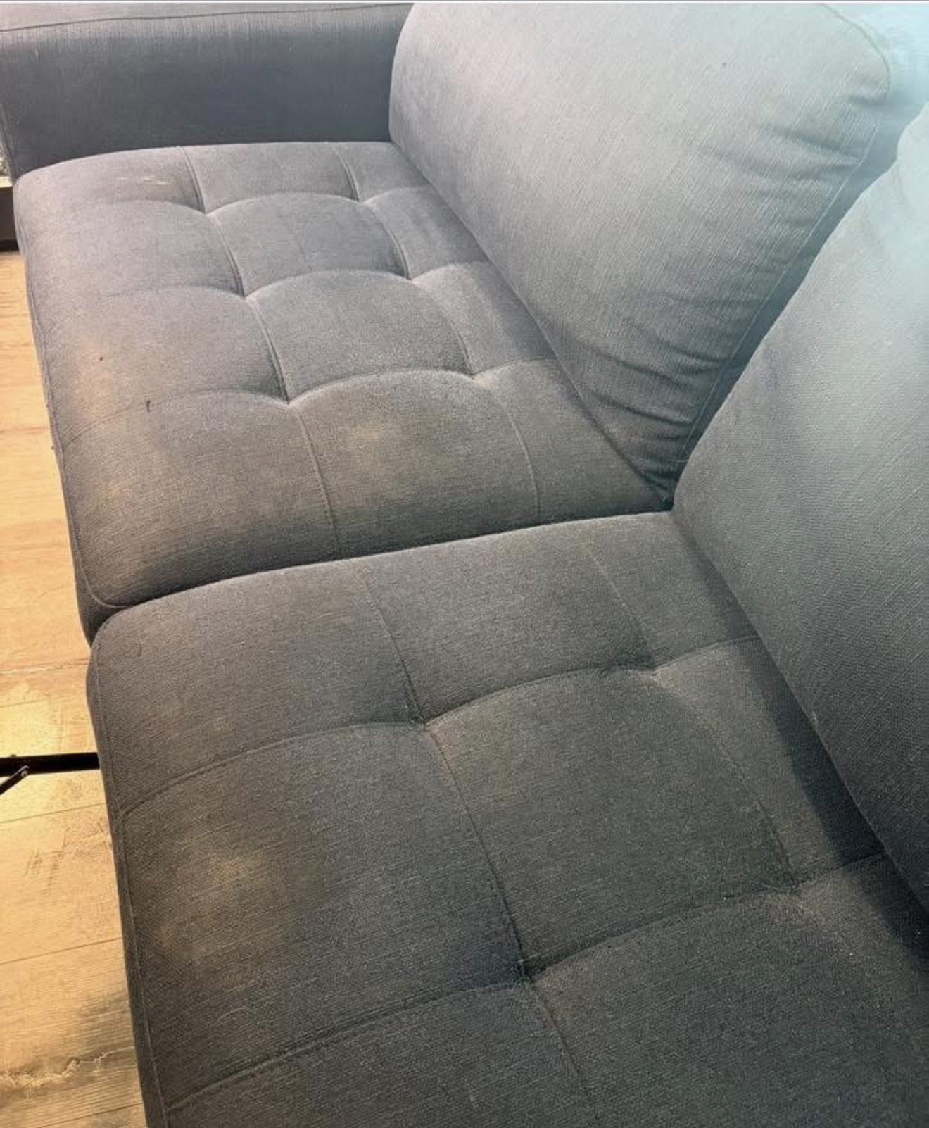 Detail of tufted gray sofa after cleaning