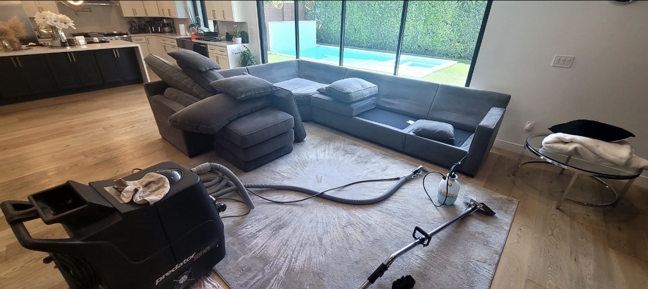 Large gray sectional sofa mid-cleaning